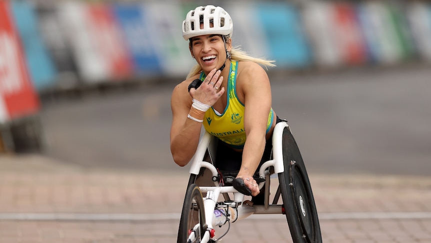 Madison de Rozario smiles as she crosses the line in the T53/54 Commonwealth Games marathon.