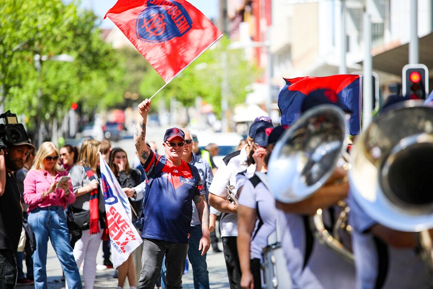 A Demons supporter waves a flag