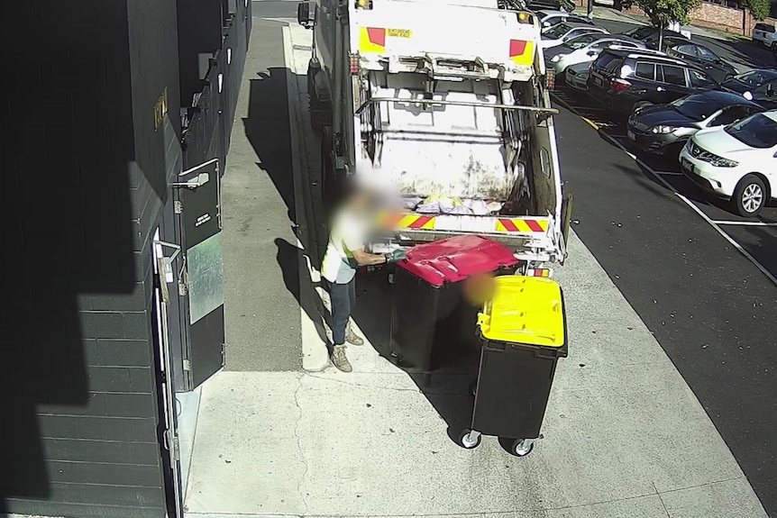 A still from a CCTV tape shows a rubbish worker loading large bins into a rubbish truck.