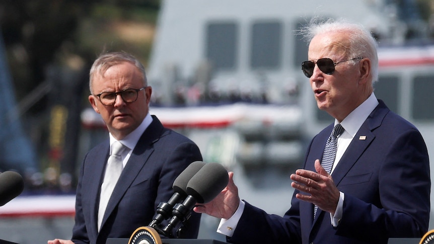 Joe Biden in sunglasses speaking while Anthony Albanese looks on