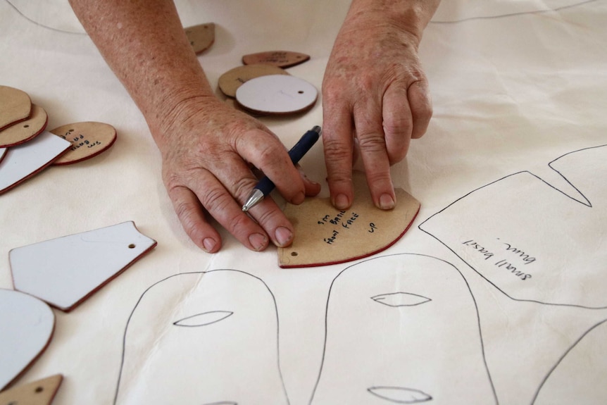 Hands are drawing a pattern on material to make a teddy