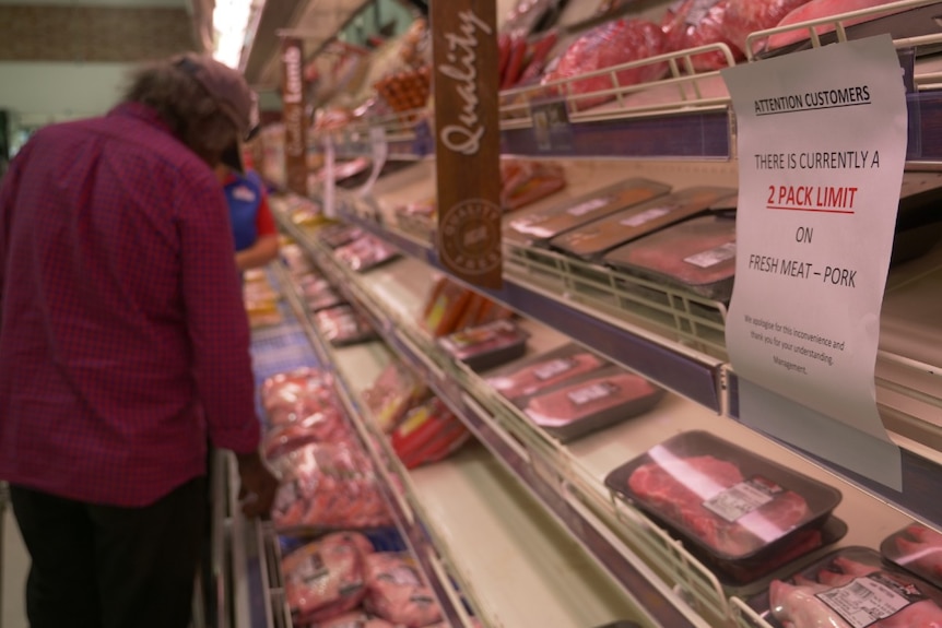 Sign of limit on meat with blurred out supermarket in background