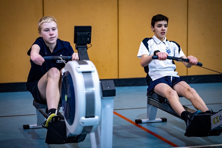 Knox on a rowing machine in school, with the elbow of his amputated arm gripping the handle.