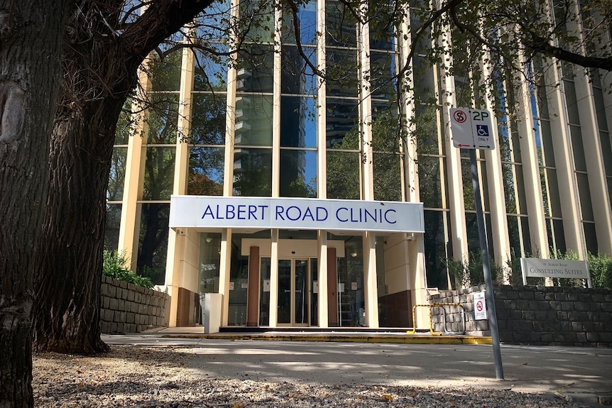 The exterior of a modern looking building with a sign above the door saying Albert Road Clinic.