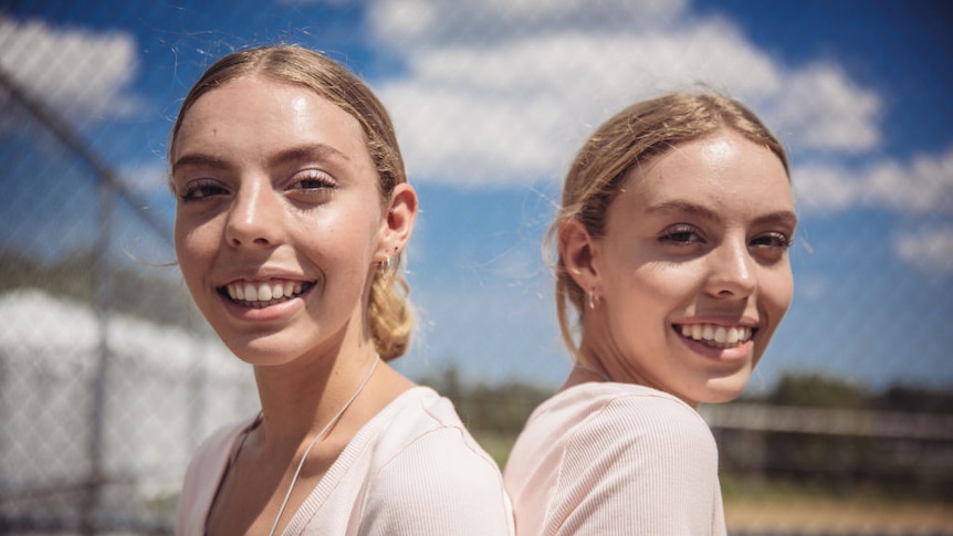 Identical twin sisters smiling