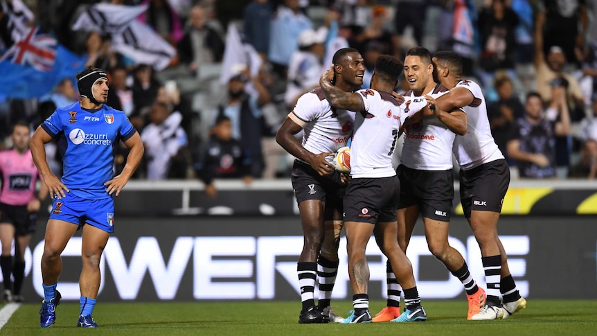 Fiji's Suliasi Vunivalu celebrates with team-mates after scoring a try against Italy