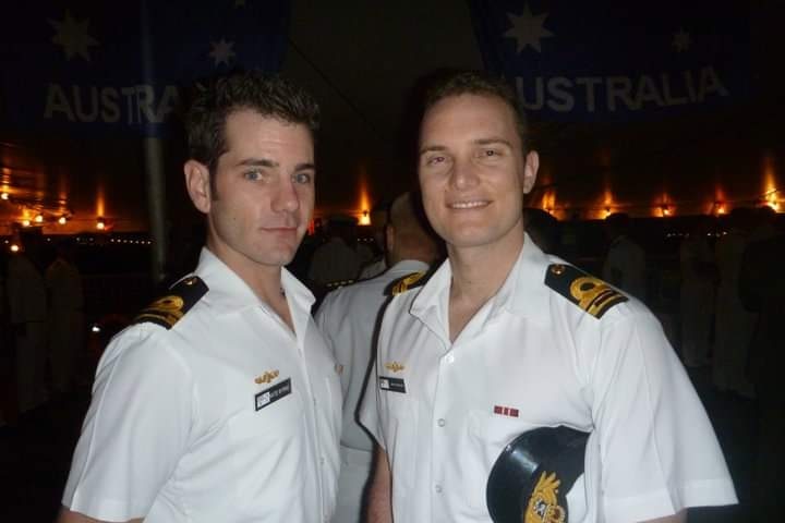 Two men wearing white naval uniforms.