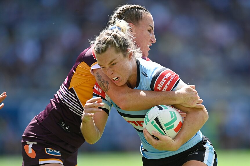 Cronulla Sharks' Emma Tonegato is tackled by Ali Brigginshaw of the Brisbane Broncos during an NRL Women's match.
