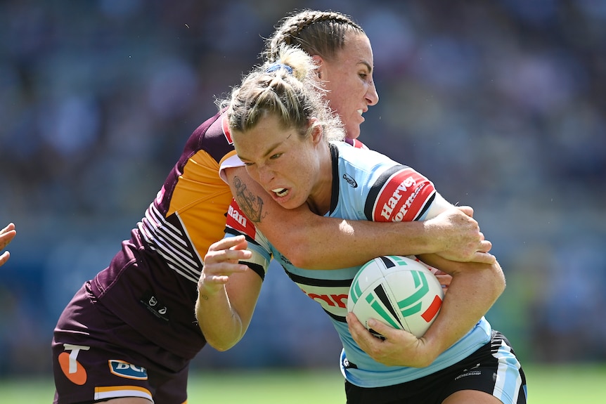 Cronulla Sharks' Emma Tonegato is tackled by Ali Brigginshaw of the Brisbane Broncos during an NRL Women's match.