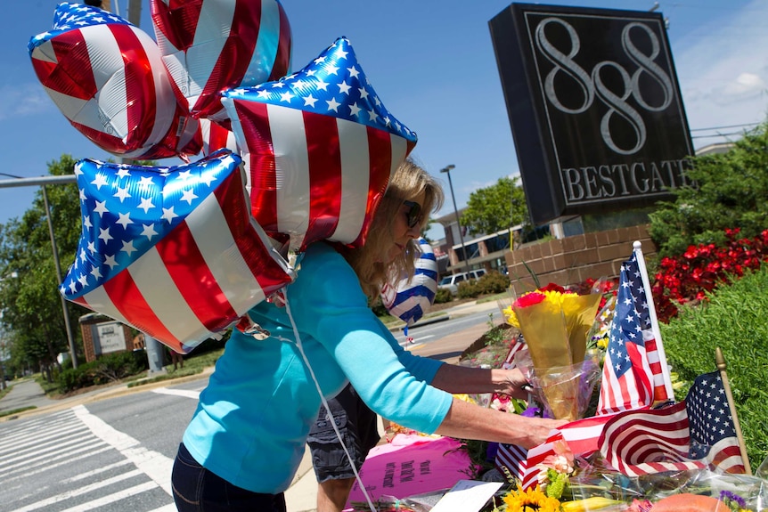 Kathaleen Novick place flowers at makeshift memorial