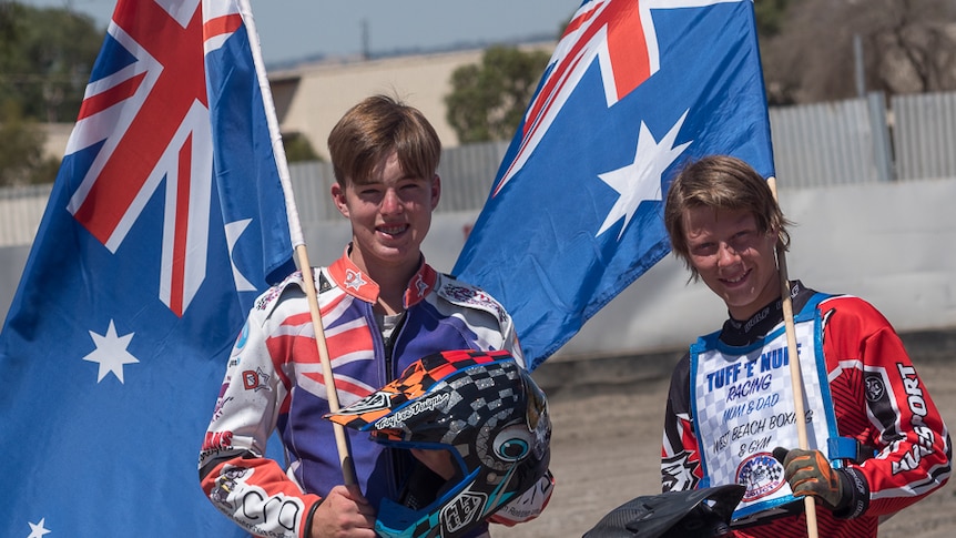 Brayden McGuinness and Jack Norman hold Australian flags.
