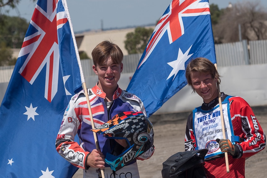 Brayden McGuinness and Jack Norman hold Australian flags.