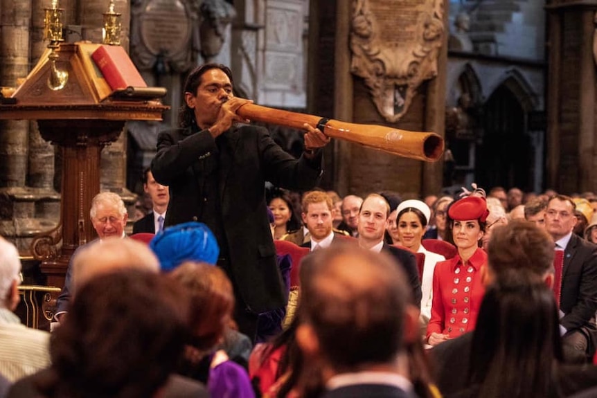 man plays didgeridoo in Westminster Abbey