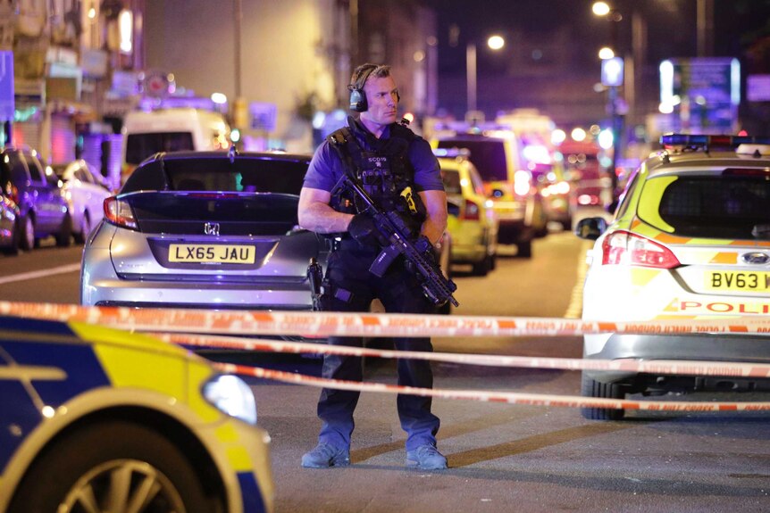 An armed officer mans a cordon, carries a firearm near where a vehicle struck pedestrians at Finsbury Park.
