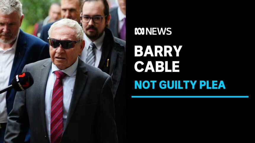 Barry Cable, Not Guilty Plea: An older man with glasses walks down the street with a media microphone in his face.