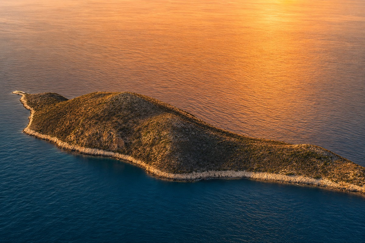 The sun sets over an island.