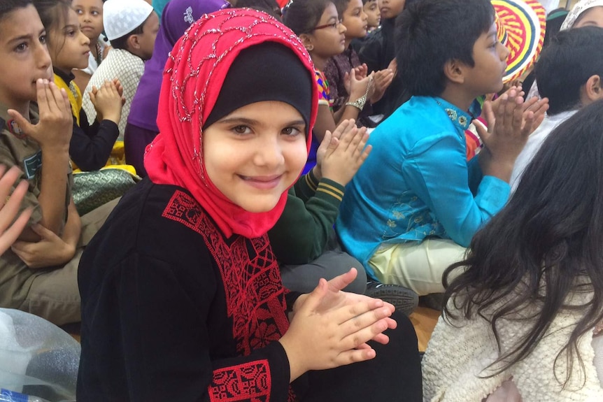 An Islamic student smiling in a group of students at a school in Tarneit.