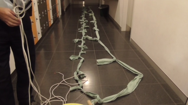 A correctional officer poses with a 10m electrical cord and a 20m rope made from sheets.
