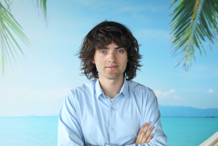 A portrait of a young man with ruffled hair and a business shirt.