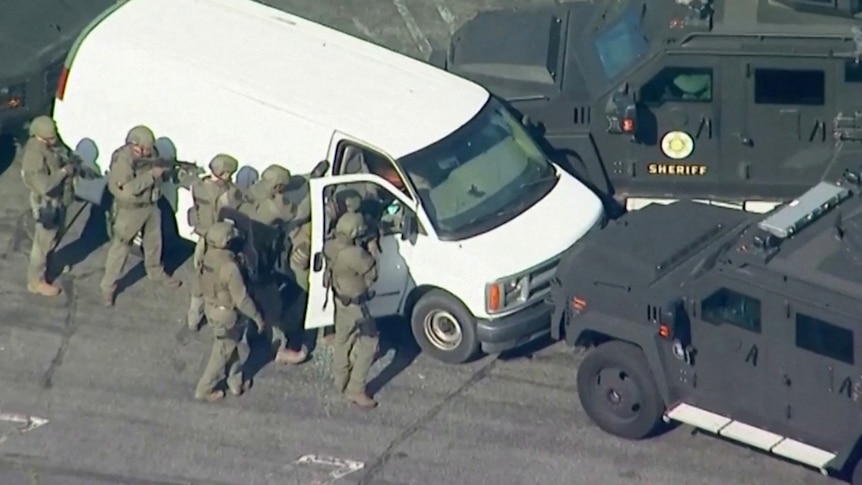 Police surround a parked white van.