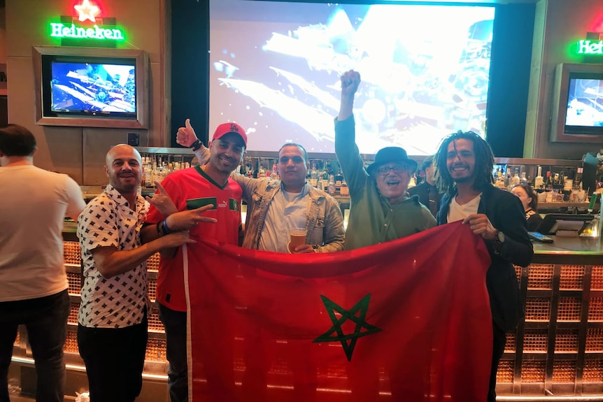 A group of men holding a Moroccan flag