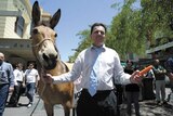 Nick Xenophon holds a donkey and carrot.