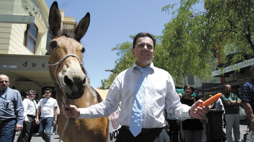 Nick Xenophon holds a donkey and carrot.