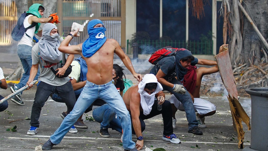 Masked protestors confront police in Caracas