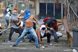 Masked protestors confront police in Caracas