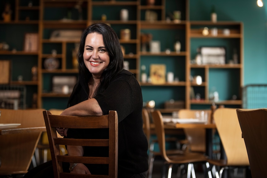 Una mujer sentada en una silla en un café.