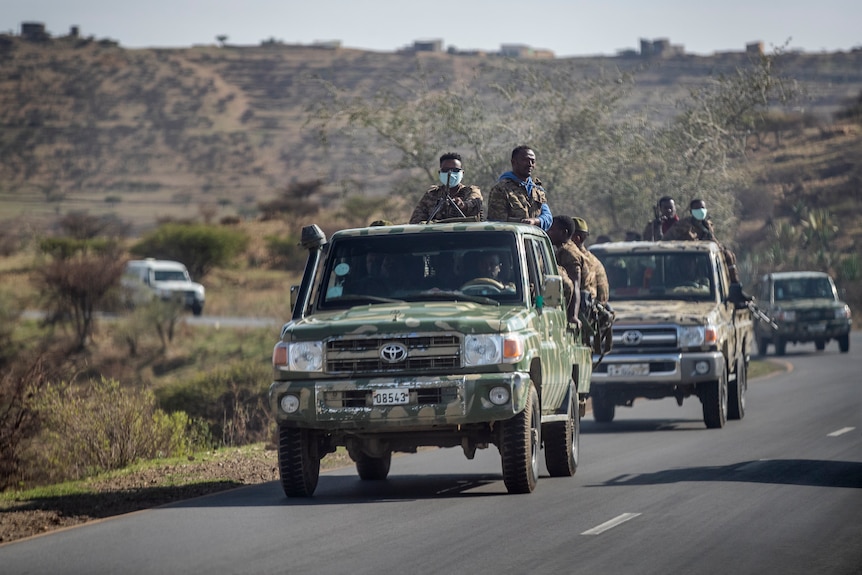 Ethiopian government soldiers ride in the back of trucks