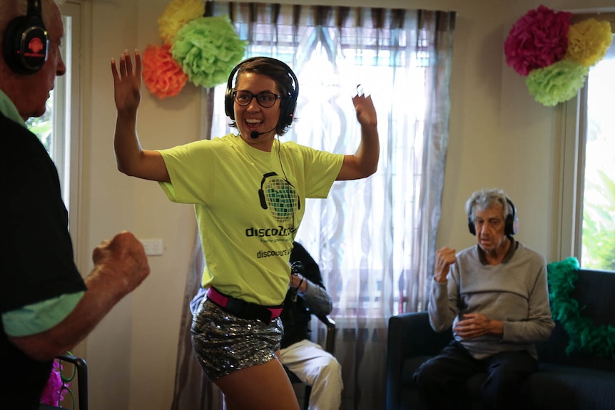 Dance instructor smiling with arms raised