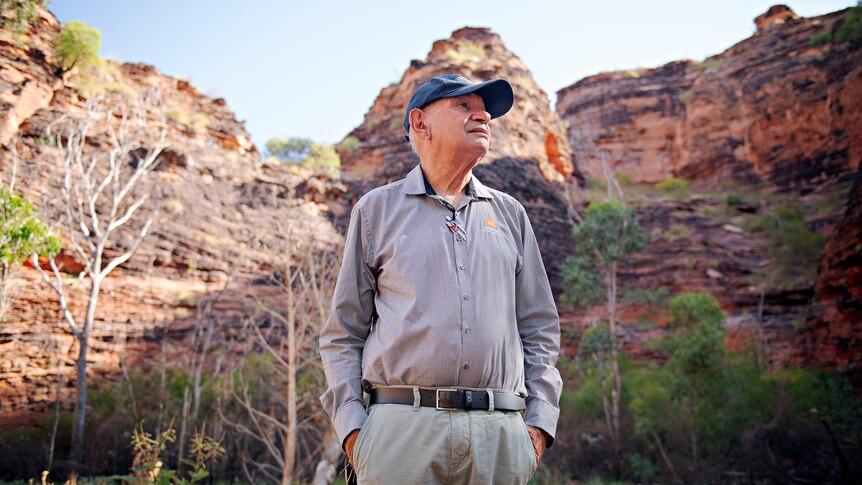 A man stands amid Kimberley red rock formations