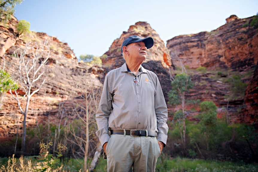 A man stands amid Kimberley red rock formations.