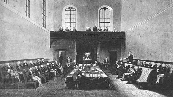 A black and white sketch of men gathered in parliamentary style in a large hall