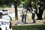 A photo showing Northern Territory police inspecting a hit and run scene in Birnkin