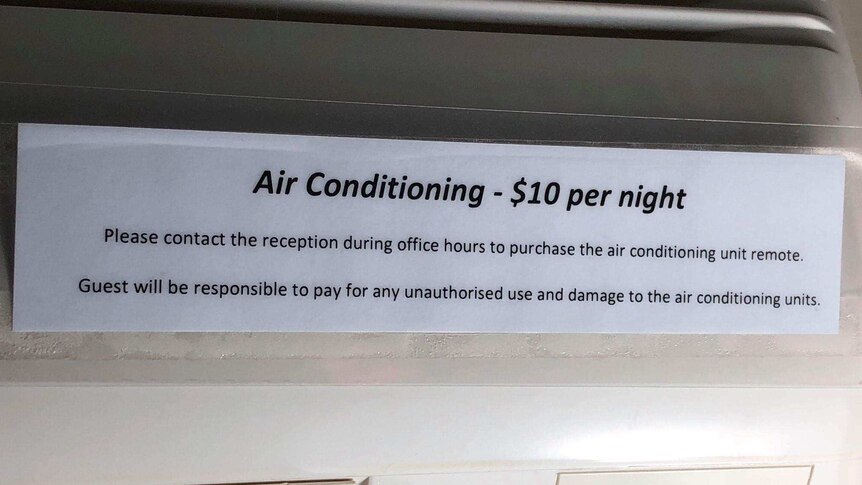 Sign on air conditioning unit in a Gold Coast holiday apartment telling guests to pay $10 per night to use the air conditioning