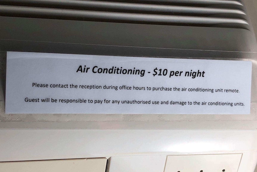 Sign on air conditioning unit in a Gold Coast holiday apartment telling guests to pay $10 per night to use the air conditioning