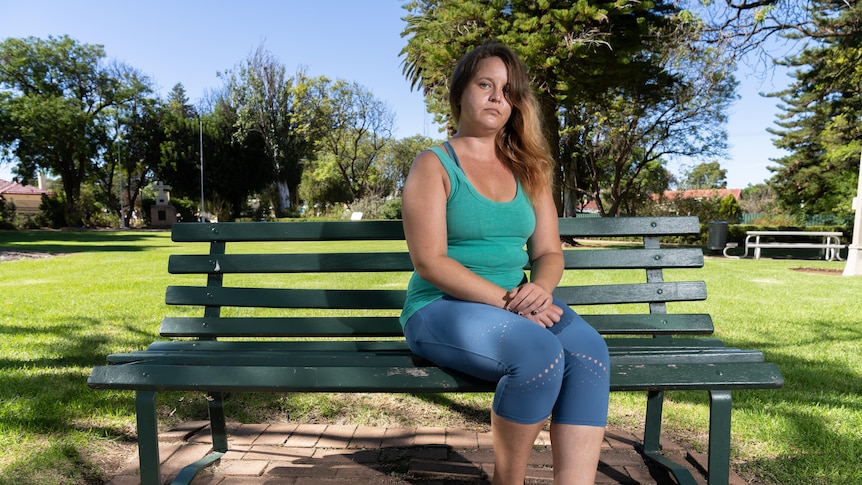 A woman sits on a park bench in suburban Adelaide.