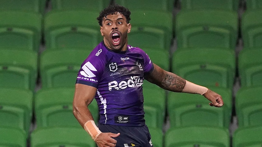 Josh Addo-Carr of the Melbourne Storm screams with his arms akimbo after scoring a try.