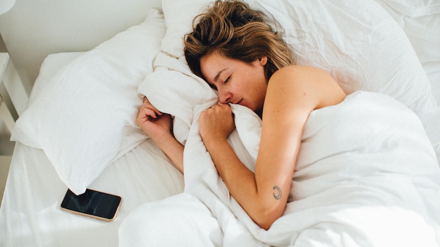 High angle view of a woman sleeping on a bed