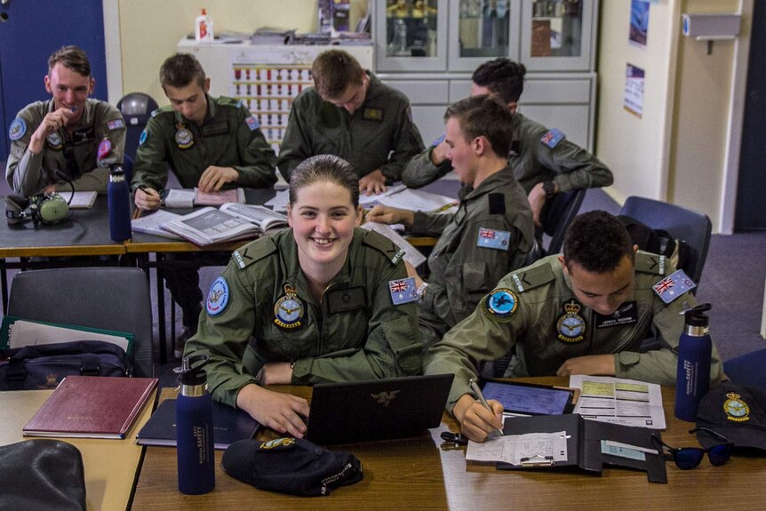 Air force cadets in uniform sitting at desks