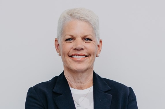 A portrait of a woman smiling at camera.