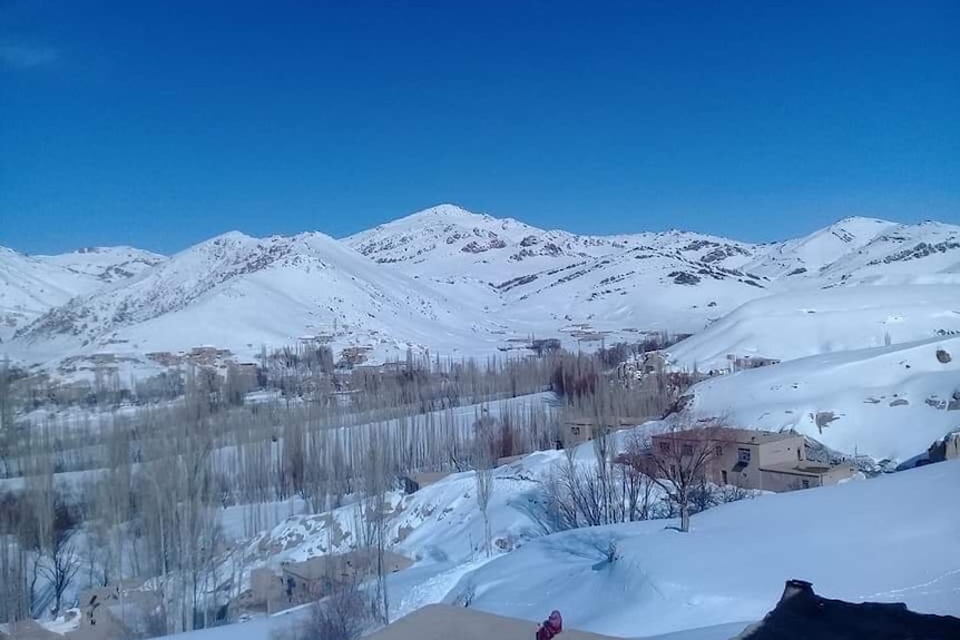 A mountainous village in Afghanistan covered with snow on its peaks. 