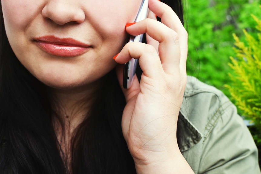 Tight half-face photo of anonymous woman on mobile phone.