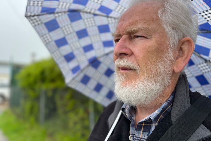Elderly man holding umbrella