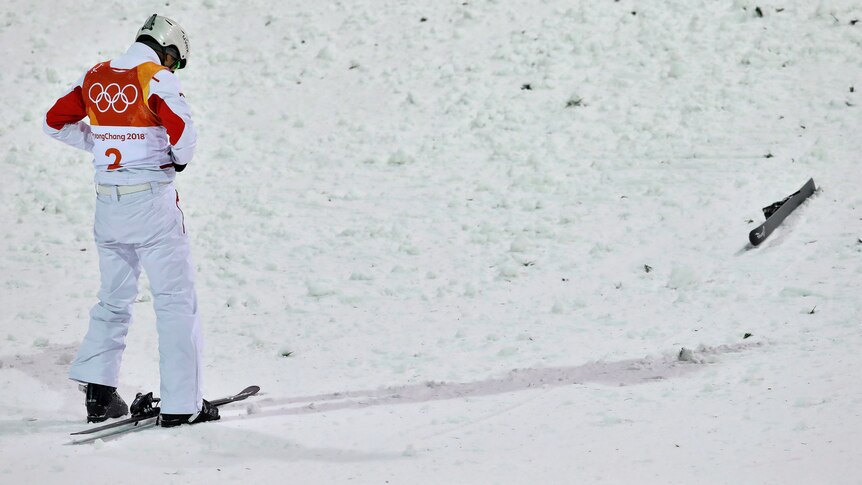 Jia Zonyang looks down at the snow after crashing following his landing on his first jump in the men's aerials final.