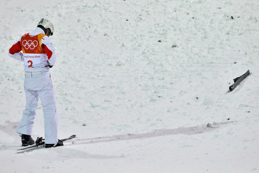 Jia Zonyang looks down at the snow after crashing following his landing on his first jump in the men's aerials final.
