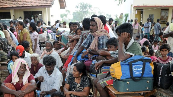 Ethnic Tamil civilians wait to go to a camp for internally displaced people