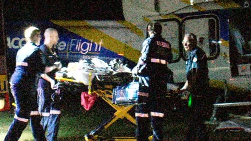 A stretcher with one of the injured boys being put in a helicopter by paramedics.